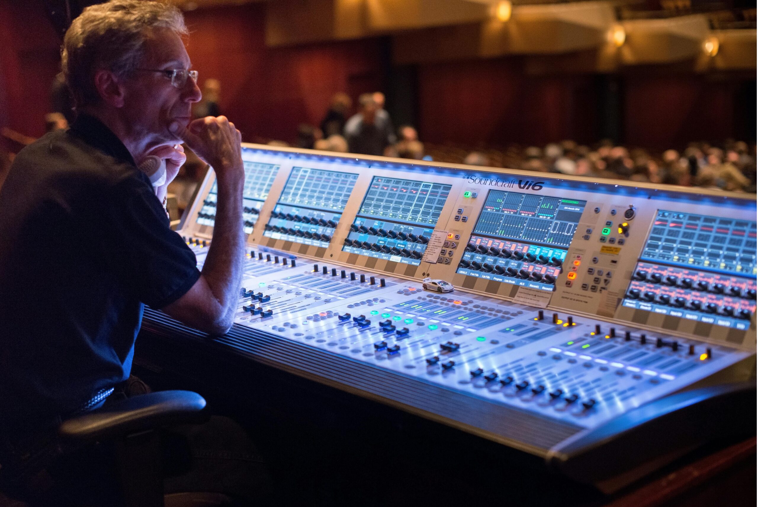 A sound engineer manages the audio control panel at a live music concert, ensuring quality sound.